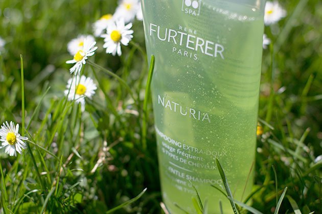 Shampoing Naturia de Furterer dans l'herbe et pâquerettes