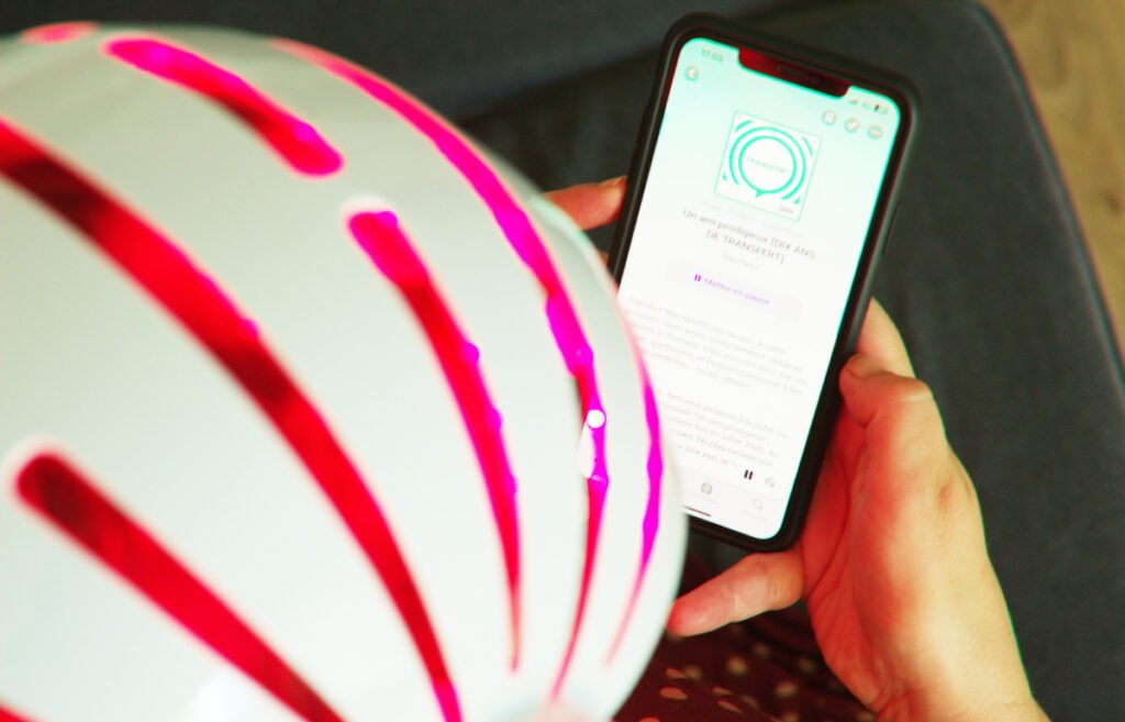Casque LED CurrentBody pour cheveux intégré dans une routine bien-être à domicile avec un podcast